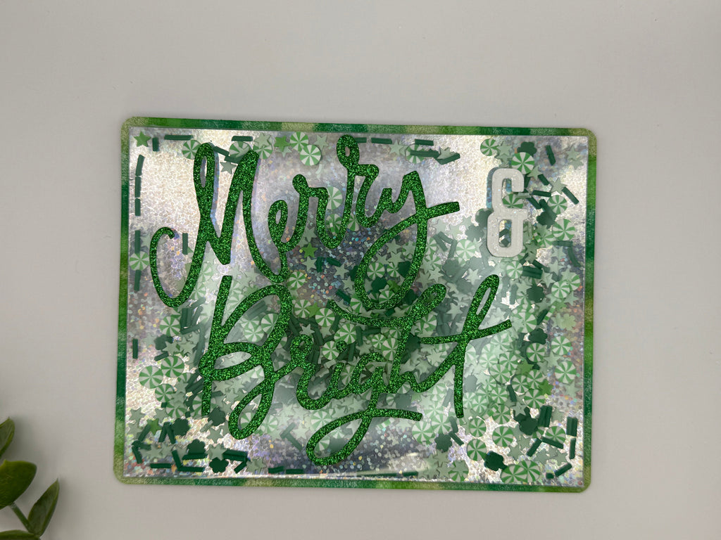 Decorative sign with 'Merry & Bright' text on a floral patterned background