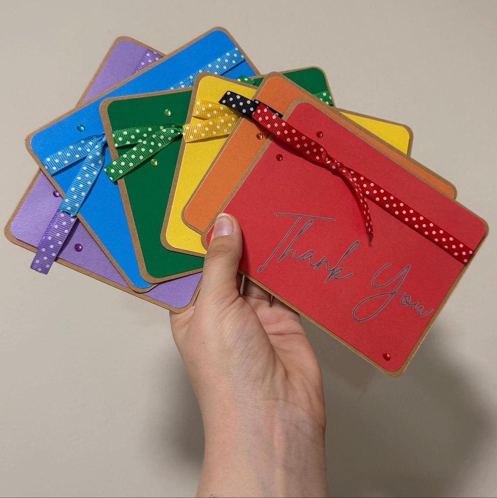 Colorful cards with 'Thank You' on a beige background
