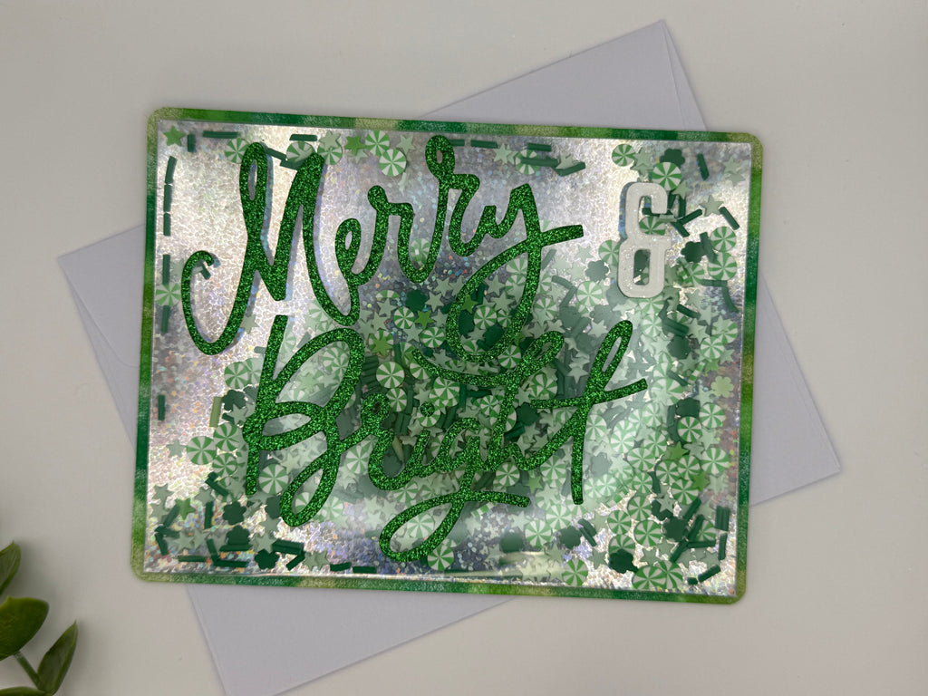 Greeting card with 'Merry & Bright' text on a textured green and silver background