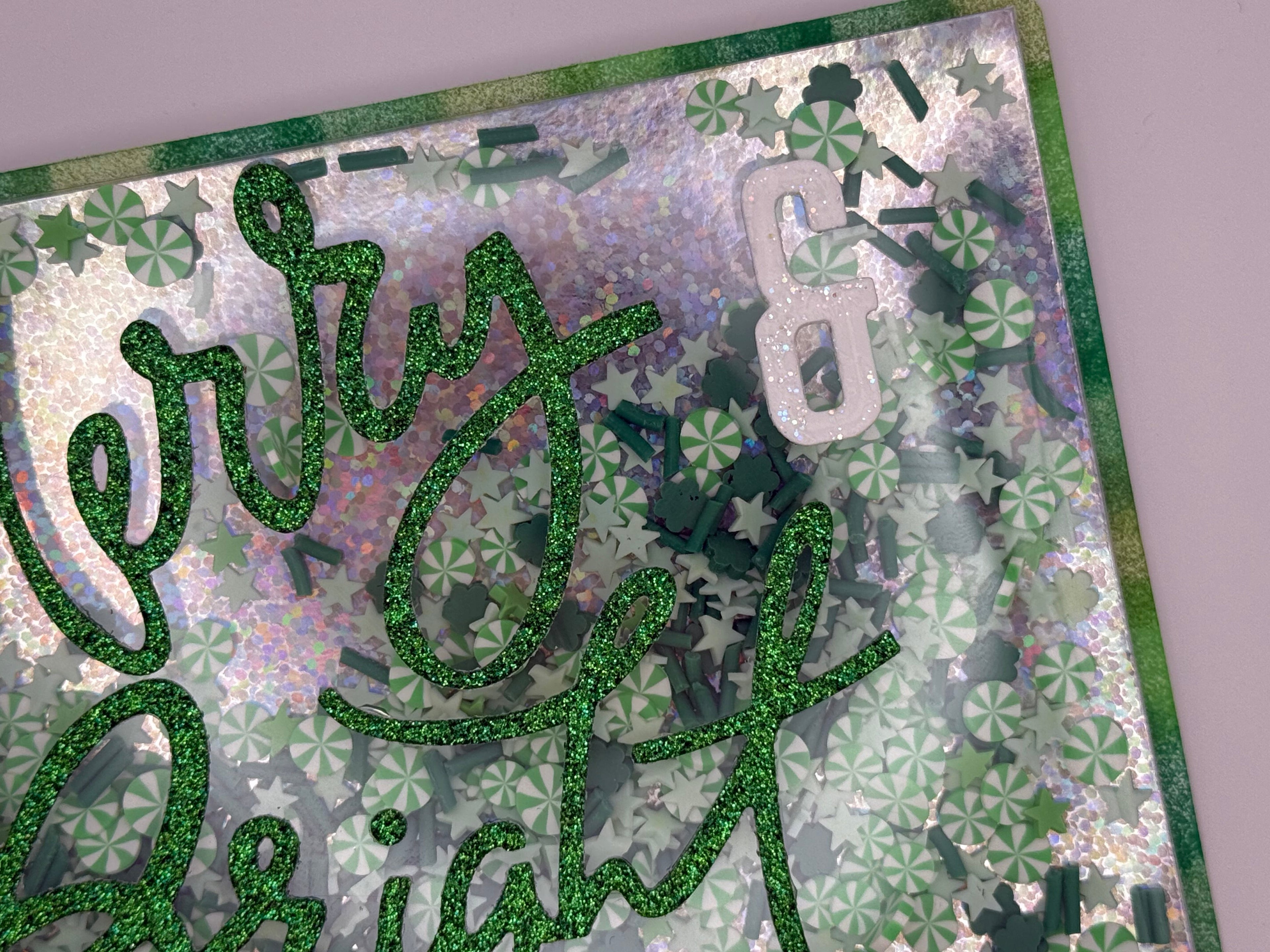 Decorative card with glittery text and shamrock patterns on a textured background