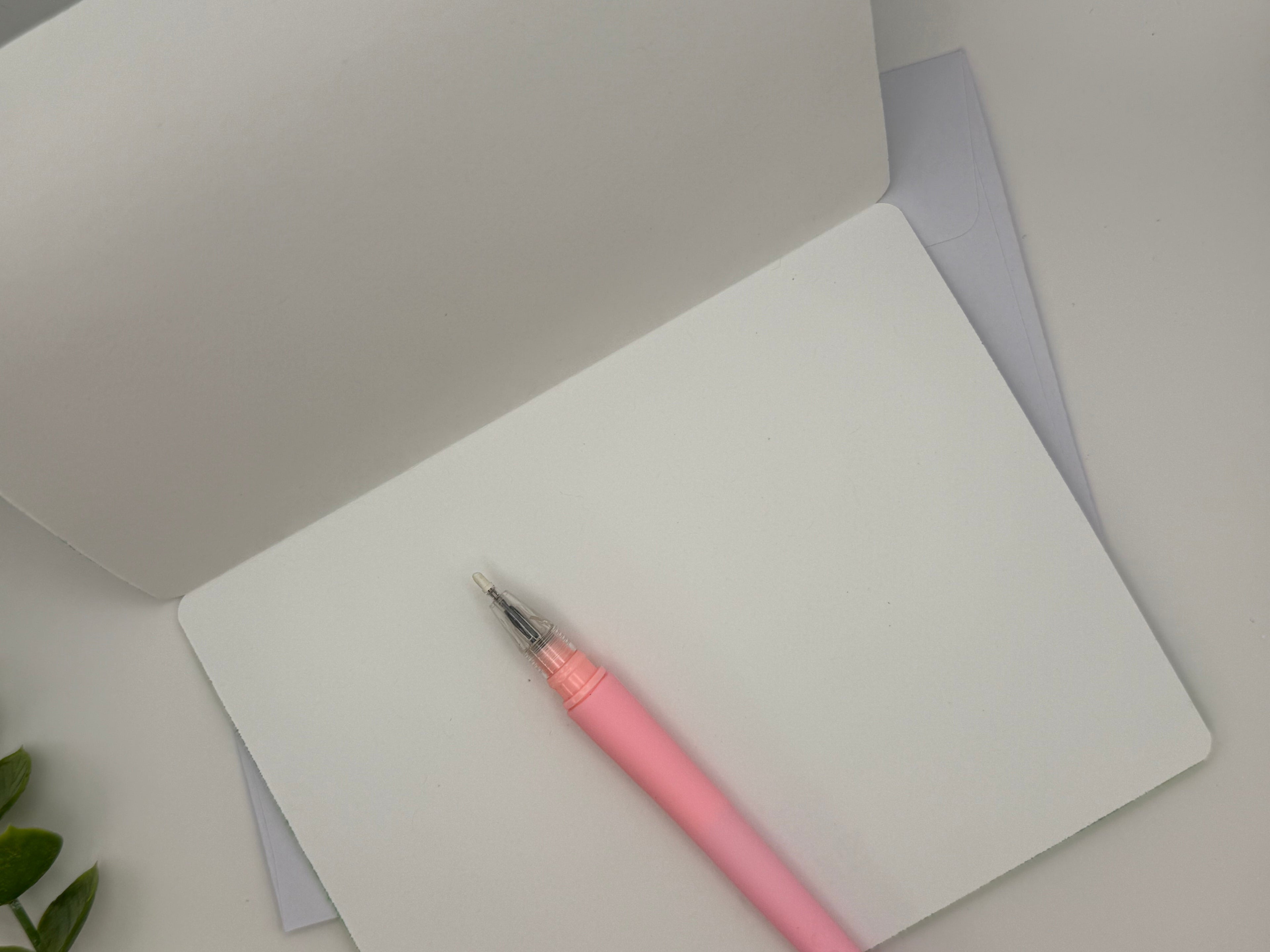 Pink pen on a white notebook with a gray background