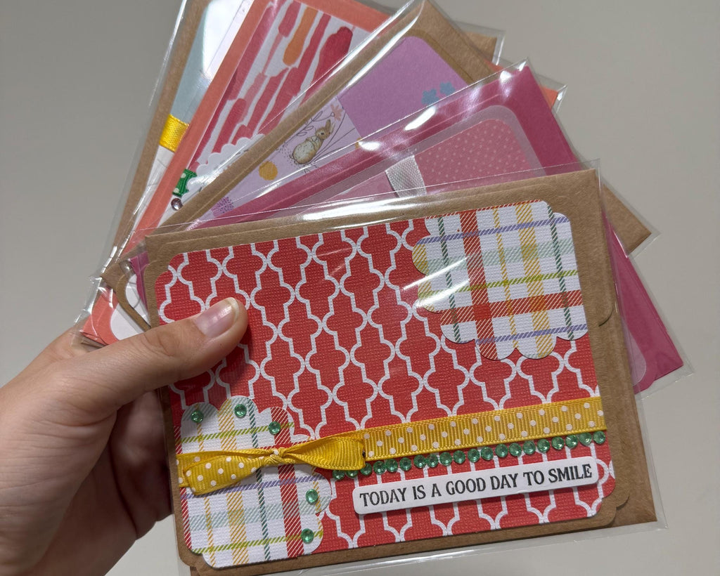 Hand holding a stack of patterned greeting cards with a visible message.